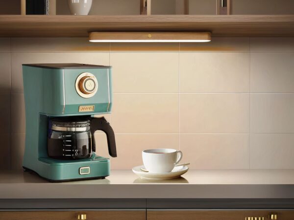 Applique murale LED magnétique, fixé sous un meuble au-dessus d'une cafetière et d'une tasse et sous tasse.
