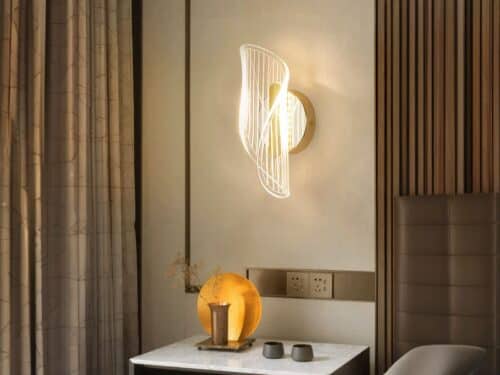 Applique murale LED luxueuse, allumée et installée sur un mur à côté d'un lit, en guise de lampe de chevet, au-dessus d'une table de nuit.