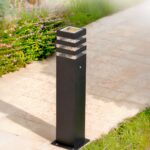 Borne extérieure LED design noir et étanche Borne extérieure LED design noir et étanche, sur une allée à côté de l'herbe.