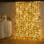 Guirlande led exterieur avec des fausses feuilles de vigne Guirlande led exterieur avec des fausses feuilles de vigne installée sur un mur avec une table à gauche