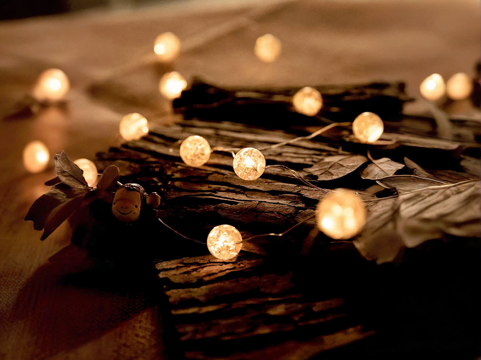 Guirlande mini LED design en forme de boules, sur un fond marron, avec lumière jaune.
