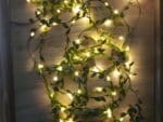 Guirlande mini LED élégante avec feuilles vertes, avec lumière jaune positionné sur le sol.