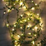 Guirlande mini LED élégante avec feuilles vertes Guirlande mini LED élégante avec feuilles vertes, avec lumière jaune positionné sur le sol.