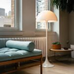 Lampadaire LED blanc moderne abat-jour champignon Lampadaire LED champignon blanc, installé dans un salon, à côté d'un chauffage et d'un sofa avec des coussins vert.