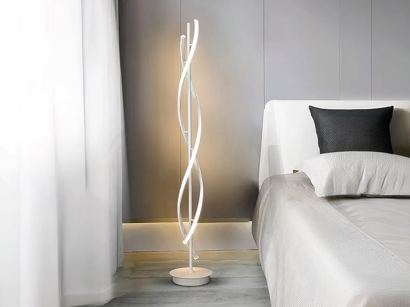 Lampadaire LED en spirale au design moderne Lampadaire LED blanc, en spirale au design moderne, installé à côté d'un lit.