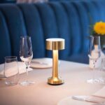 Lampe à poser LED dorée élégante et design Lampe à poser LED dorée élégante et design, sur une table.