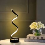 Lampe à poser LED noire à spirale Lampe à poser LED noire à spirale, sur une table blanche.