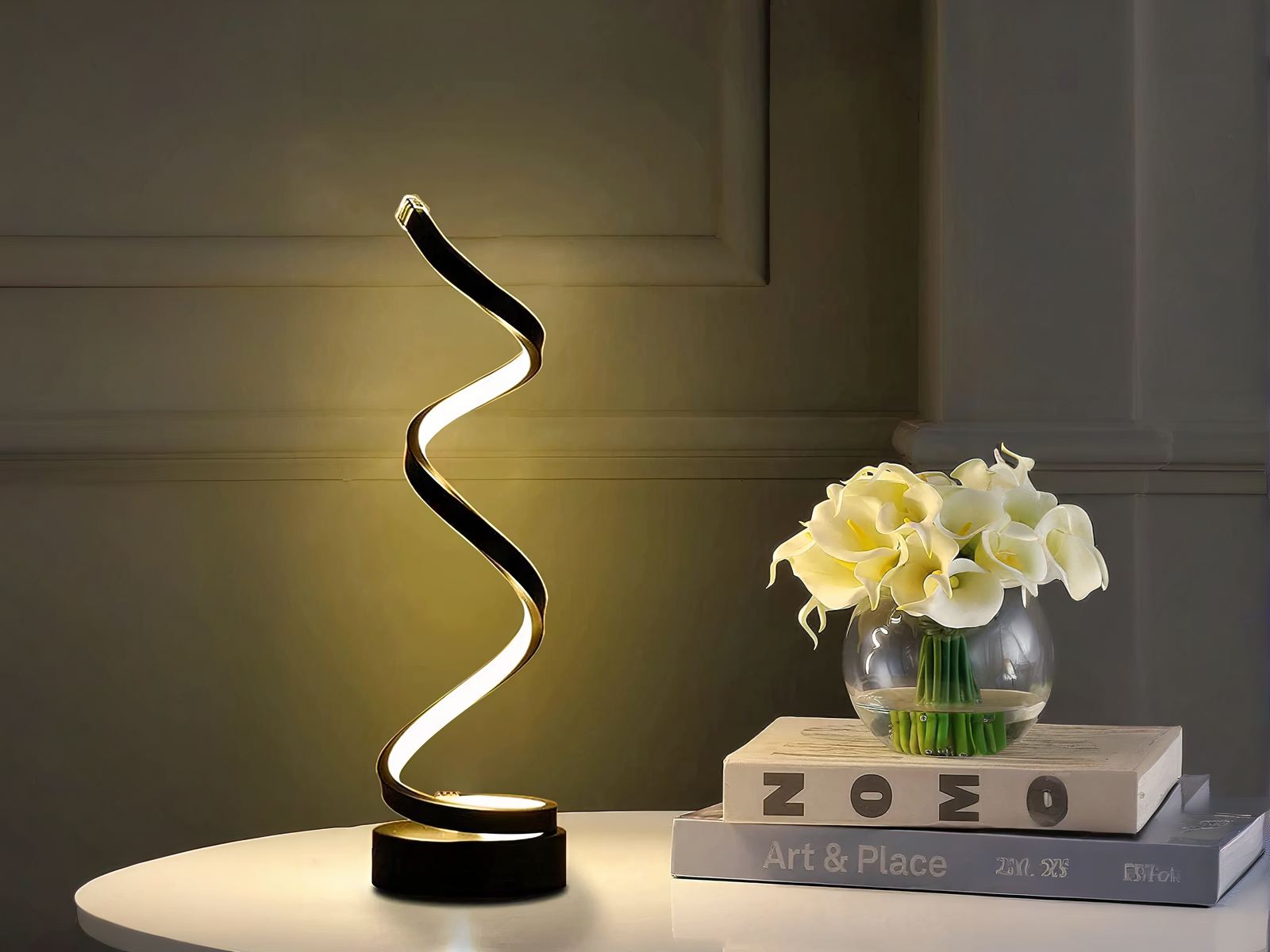Lampe à poser LED noire à spirale, sur une table blanche.