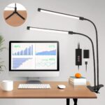 Lampe de bureau LED flexible et polyvalente Lampe de bureau LED flexible et polyvalente installée et allumée sur un bureau de travail