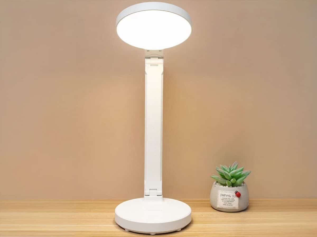 Lampe de bureau LED pliante et créative Lampe de bureau LED pliante et créative posée sur un bureau et allumée