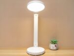 Lampe de bureau LED pliante et créative posée sur un bureau et allumée