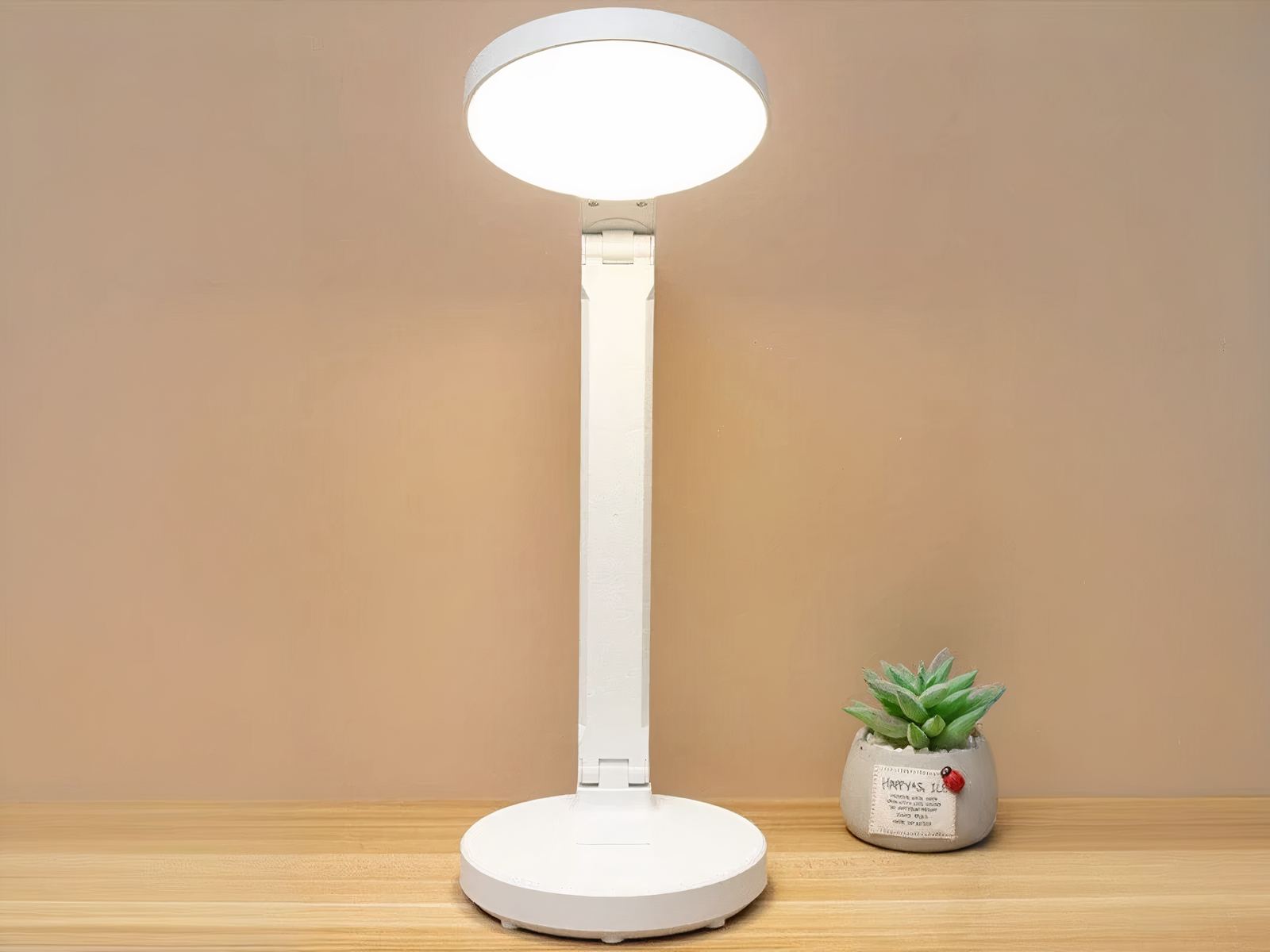 Lampe de bureau LED pliante et créative posée sur un bureau et allumée