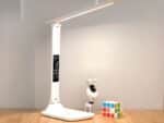 Lampe de bureau LED pliante et tactile allumée sur un bureau