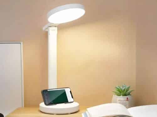 Lampe de bureau LED pratique et ergonomique allumée sur un bureau