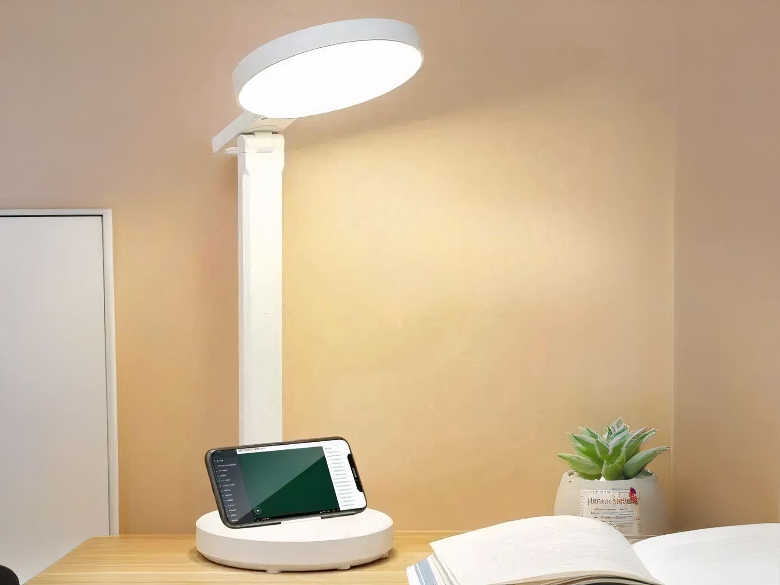Lampe de bureau LED pratique et ergonomique allumée sur un bureau