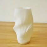 Lampe de chevet LED blanche élégante et design Lampe de chevet LED blanche élégante et design plissé, sur une table en bois.