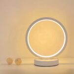 Lampe de chevet LED en forme d'anneau blanc Lampe de chevet LED en forme d'anneau blanc, posée sur une table blanche.