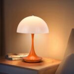 Lampe de chevet LED en forme de champignon orange, sur une table de chevet.