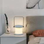 Lampe de chevet LED pliante et design blanc Lampe de chevet LED pliante et design blanc, sur une table de chevet.