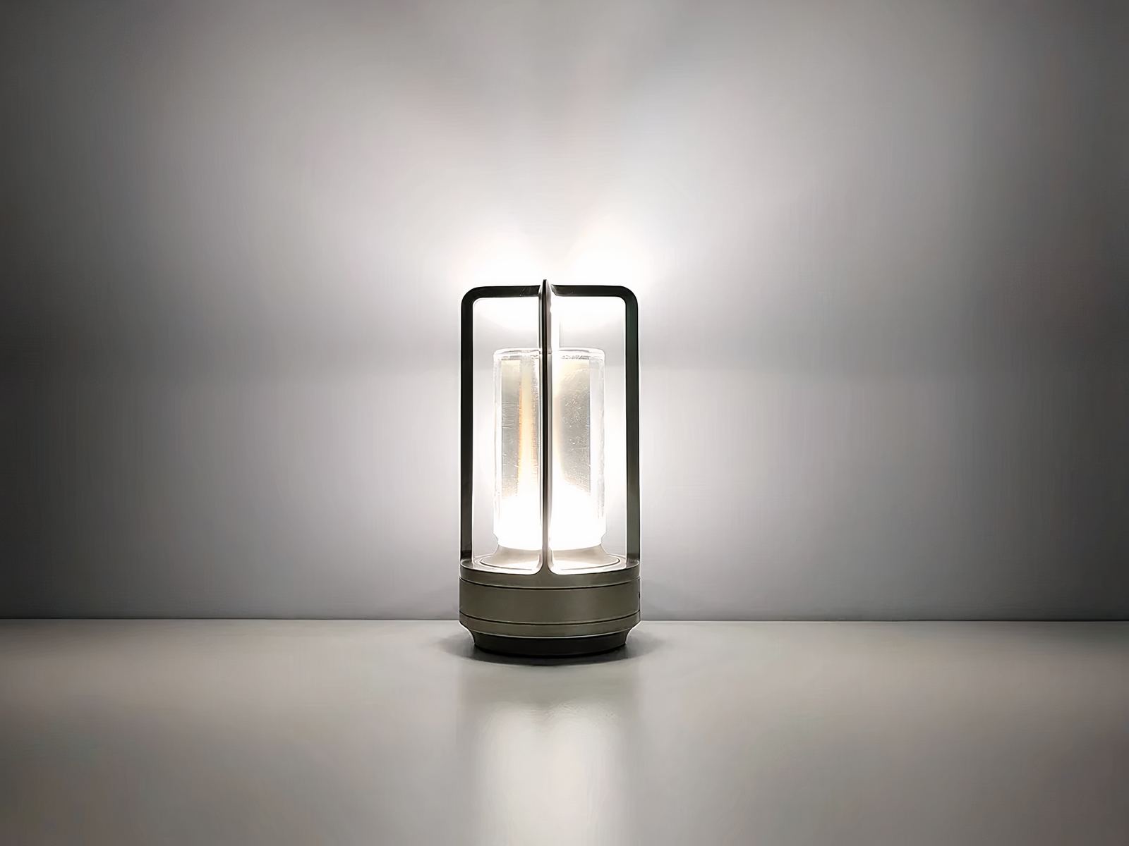 Lampe de chevet LED style lanterne en aluminium argenté, sur un fond gris.