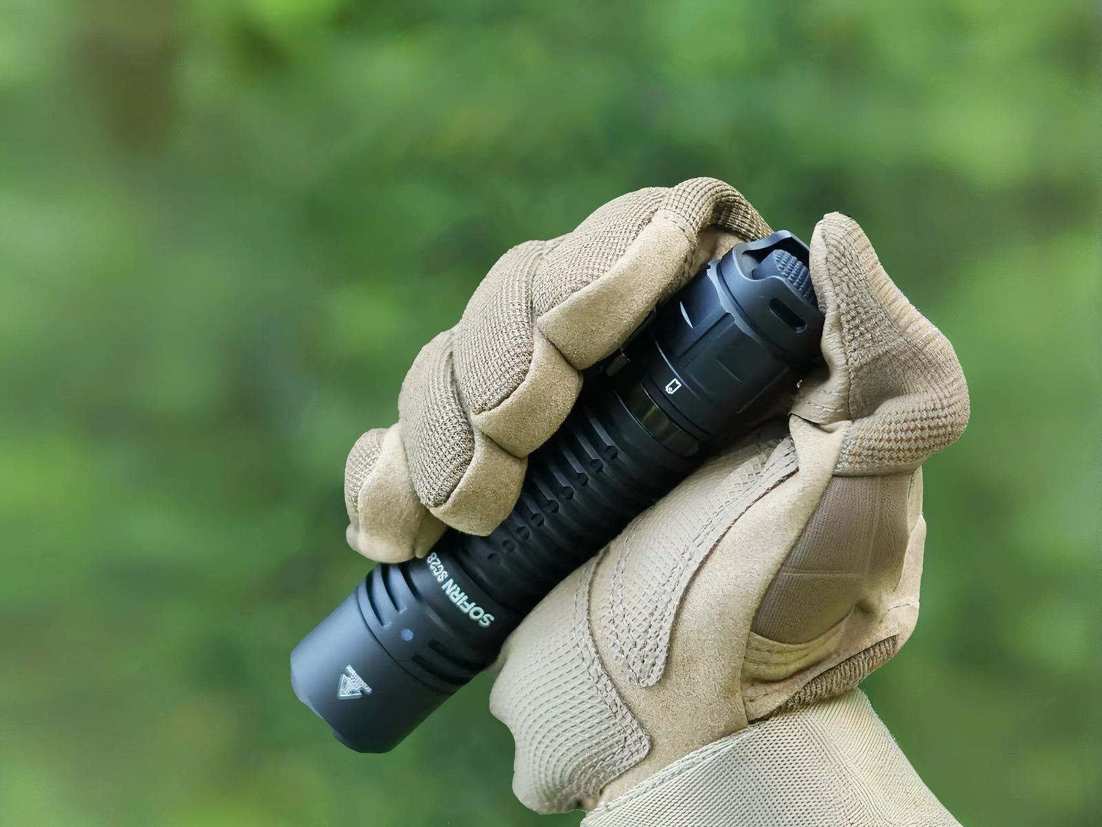 Lampe torche LED étanche et durable Lampe torche LED étanche et durable tenue dans une main avec gant sur fond vert