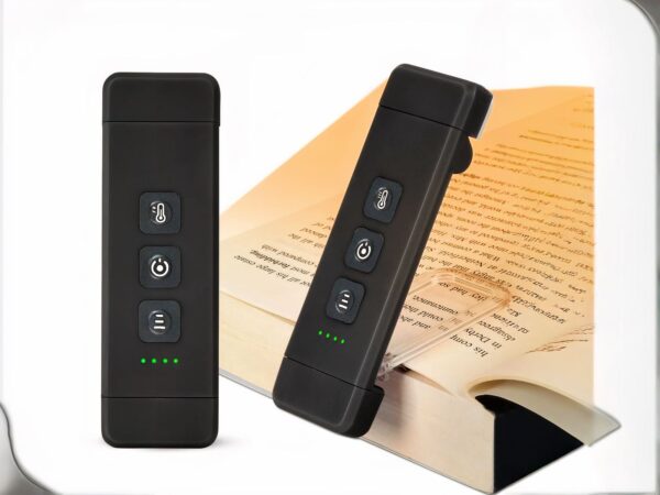 Liseuse LED noire allumée et glissé dans le page d'un livre grâce à sa pince conçue pour.