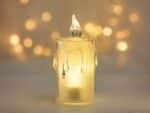 Lot de 24 bougies LED flamme vacillante avec lumière jaune, sur un fond gris.