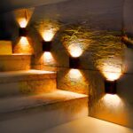 Lot de 4 appliques LED solaires noires design et étanches, le long d'un escalier.
