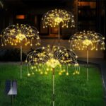 Lot de 4 lampes LED solaires en forme de feux d'artifices Lot de 4 Lampes LED solaires en forme de feux d'artifices, dans un jardin.