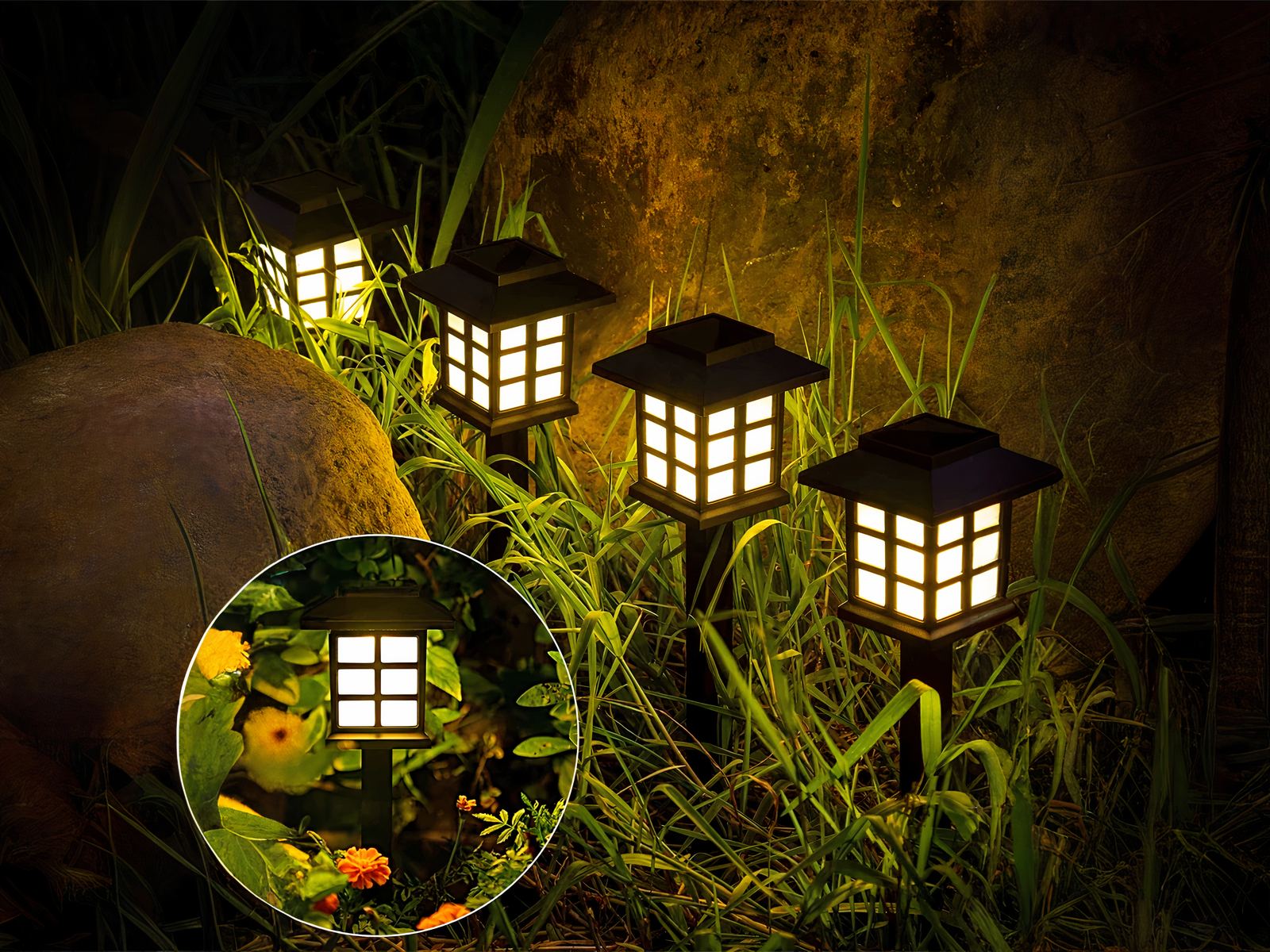 Lot de 4 lampes LED solaires noires style lanternes design, dans un massif.