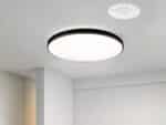 Luminaire LED moderne et design pour l'intérieur, de forme ronde, avec contour noir, sur un plafond.
