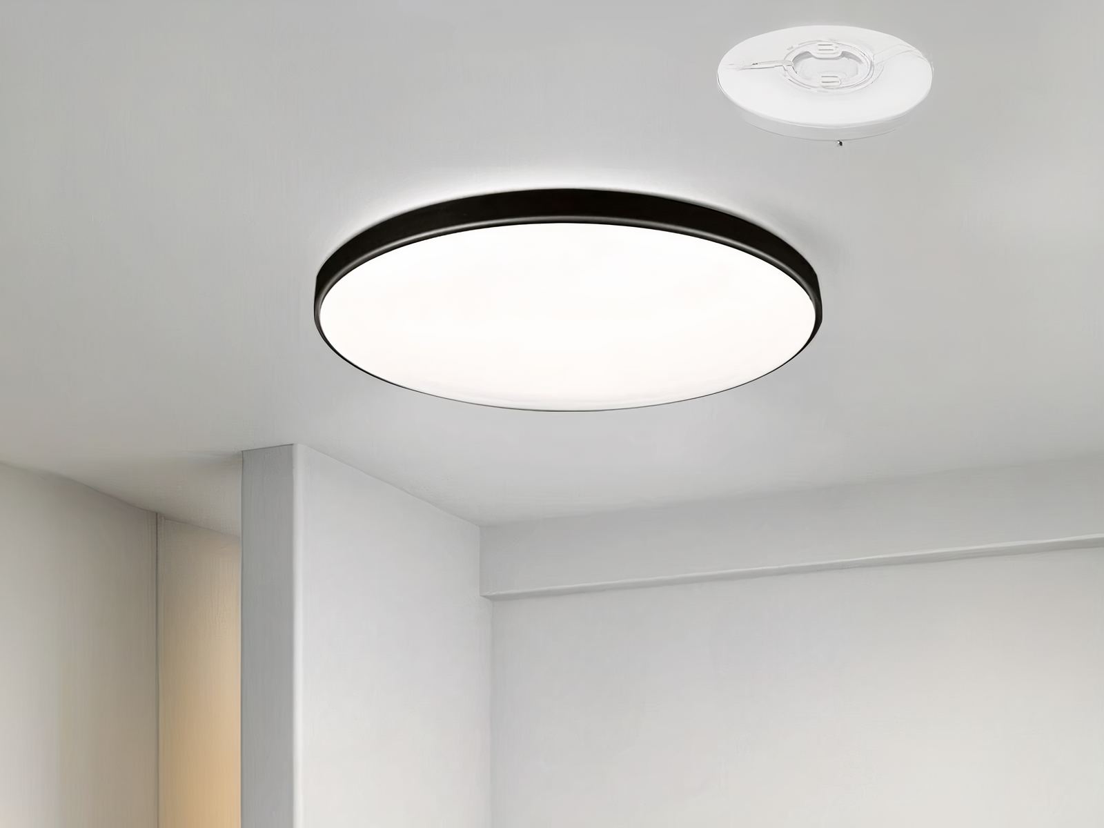 Luminaire LED moderne et design pour l'intérieur, de forme ronde, avec contour noir, sur un plafond.