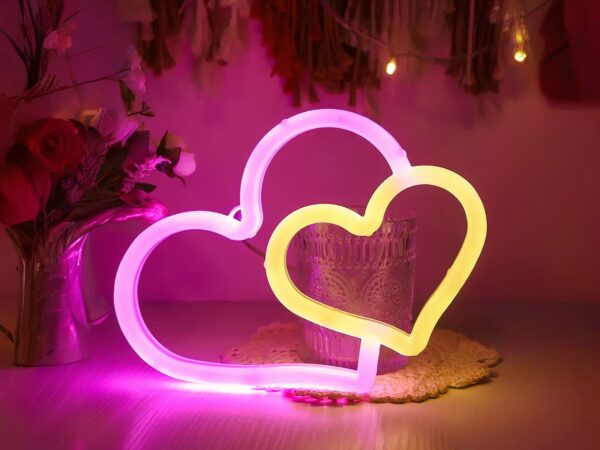 Néon LED design en forme de coeur, de couleur rose et jaune.