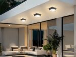 Plafonnier LED exterieur robuste et design installé sur le plafond d'une terrasse avec un canapé, des baies vitrées et des plantes vertes en dessous