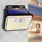 Projecteur LED solaire tendance et sans fil Projecteur LED solaire tendance et sans fil installé sur un mur gris avec une maison en fond