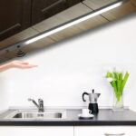 Réglette LED cuisine avec capteur de mouvements Réglette LED de cuisine avec capteur de balayage, allumée et installée sous un meuble haut au-dessus d'un évier.