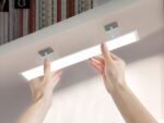 Réglette LED cuisine allumée, une personne la décroche du meuble sur lequel elle est installée.