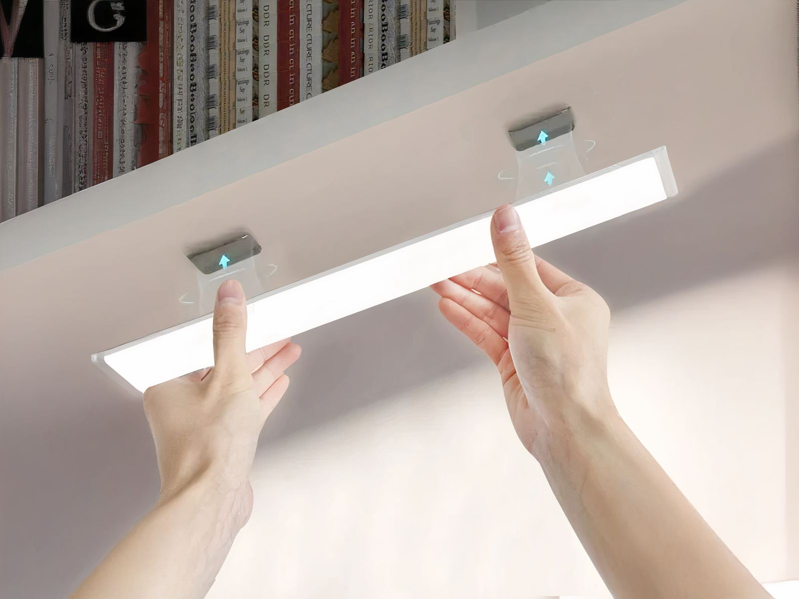 Réglette LED cuisine magnétique avec capteur de mouvement Réglette LED cuisine allumée, une personne la décroche du meuble sur lequel elle est installée.