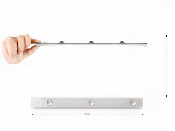 Réglette LED de cuisine, allumée et installée sous un meuble haut de cuisine. Une main passe pour déclencher le détecteur de mouvement.