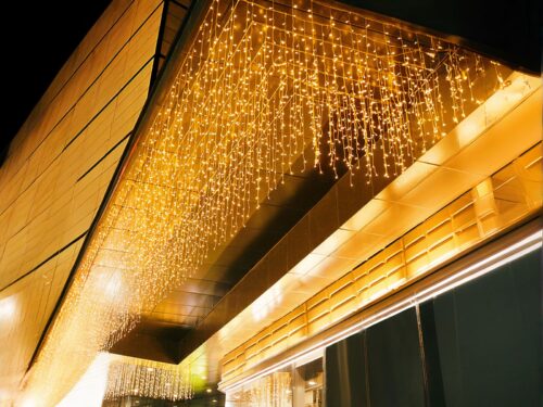 Rideau LED brillant de décoration extérieure allumé et accroché à un balcon