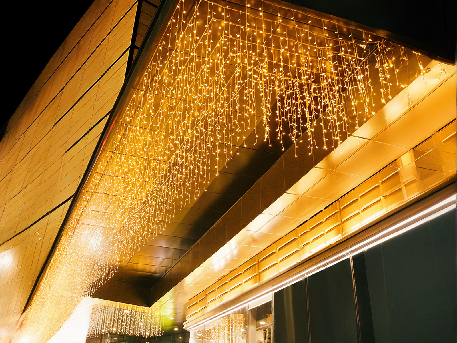 Rideau LED brillant de décoration extérieure allumé et accroché à un balcon