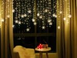 Rideau LED design en forme de flocon de neige installé et allumé dans un intérieur
