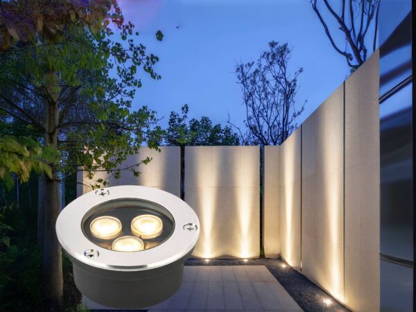 Spot LED extérieur encastrable imperméable et compact avec 3 sources lumineuses, en bas à gauche d'une photo de mur de jardin éclairé par le spot.