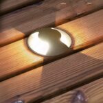 Spot LED extérieur encastrable sol acier inoxydable Spot LED extérieur encastrable dans le sol en acier inoxydable, allumé et installé dans une lame de terrasse en bois.