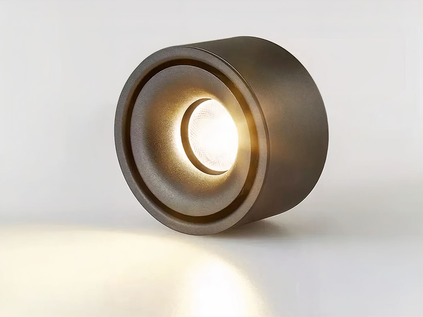 Spot LED plafond noir et rond avec lumière chaude sur fond gris