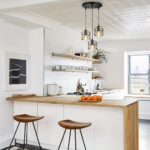 Suspension LED à trois têtes style origami Cuisine avec bar en bois, au-dessus duquel est installée une suspension LED noire avec trois têtes en style d'origami.