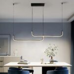 Suspension LED minimaliste et moderne noire Suspension LED noire, linéaire, allumée et installée au-dessus d'une table rectangle blanche.
