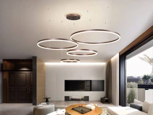 Suspension LED composée de 4 anneaux de différente taille, dispersés au plafond dans un salon moderne.