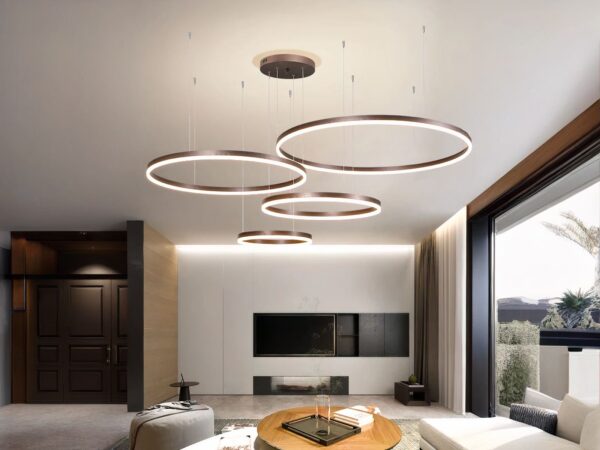Suspension LED composée de 4 anneaux de différente taille, dispersés au plafond dans un salon moderne.