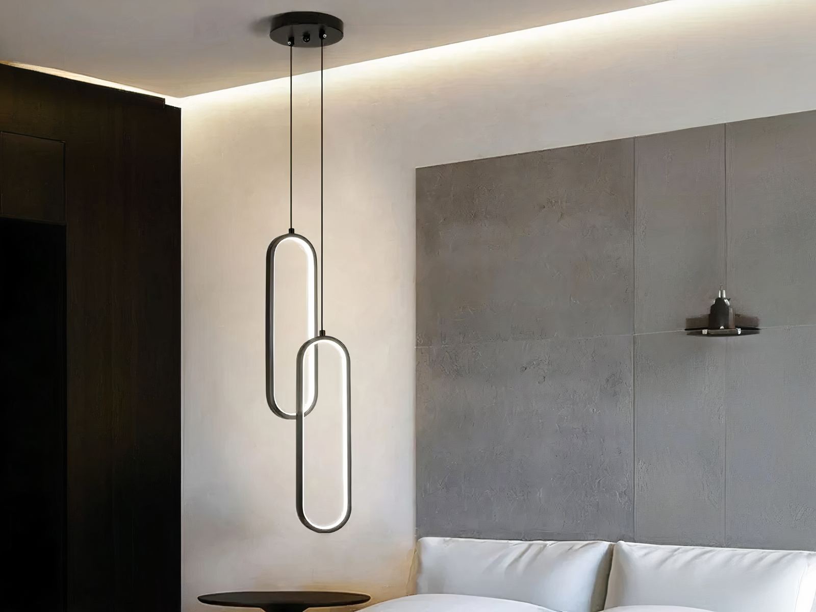 Suspension LED double moderne ovale noire Suspension LED double ovale noire, installée à côté d'un lit comme une lampe de chevet.